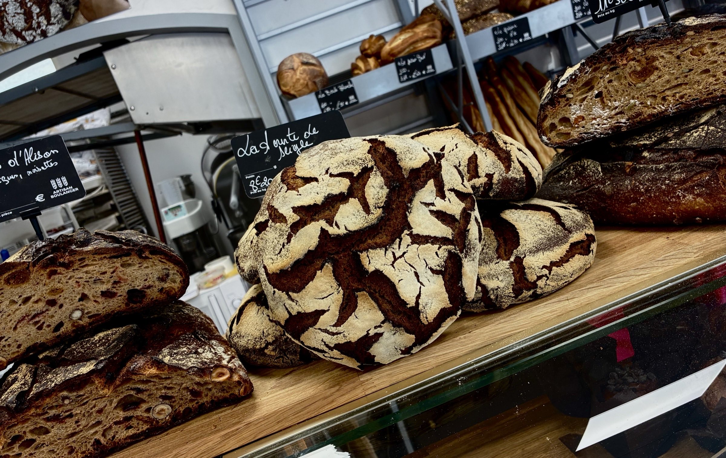 Pains au levain scarifiés et miches artisanales sur le comptoir de la boulangerie